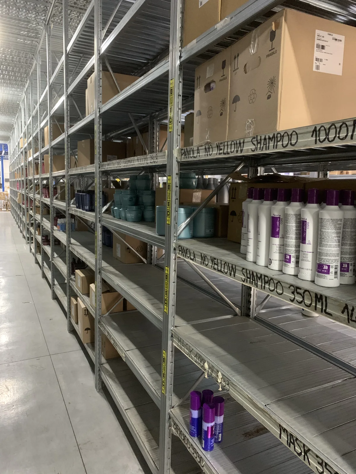 Corsia del magazzino Megaprezzo con prodotti e scatole sulle scaffalature